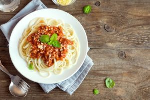 Ein Teller Spaghetti Bolognese auf einem Holztisch